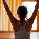 Client Chloe Liu stretching happily after a class.
